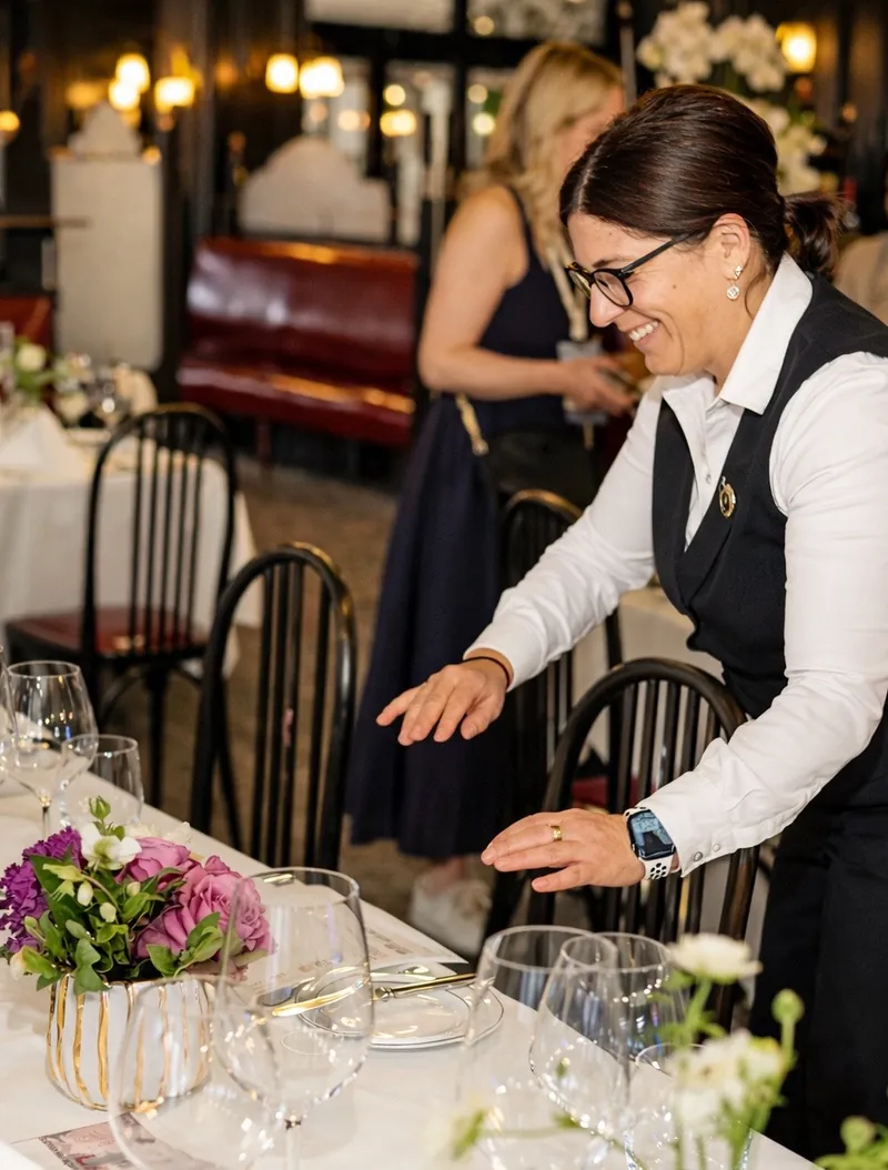 Alina setting a table in the dining room
