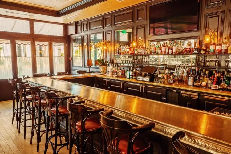 The bar, its stools and the bottles behind it