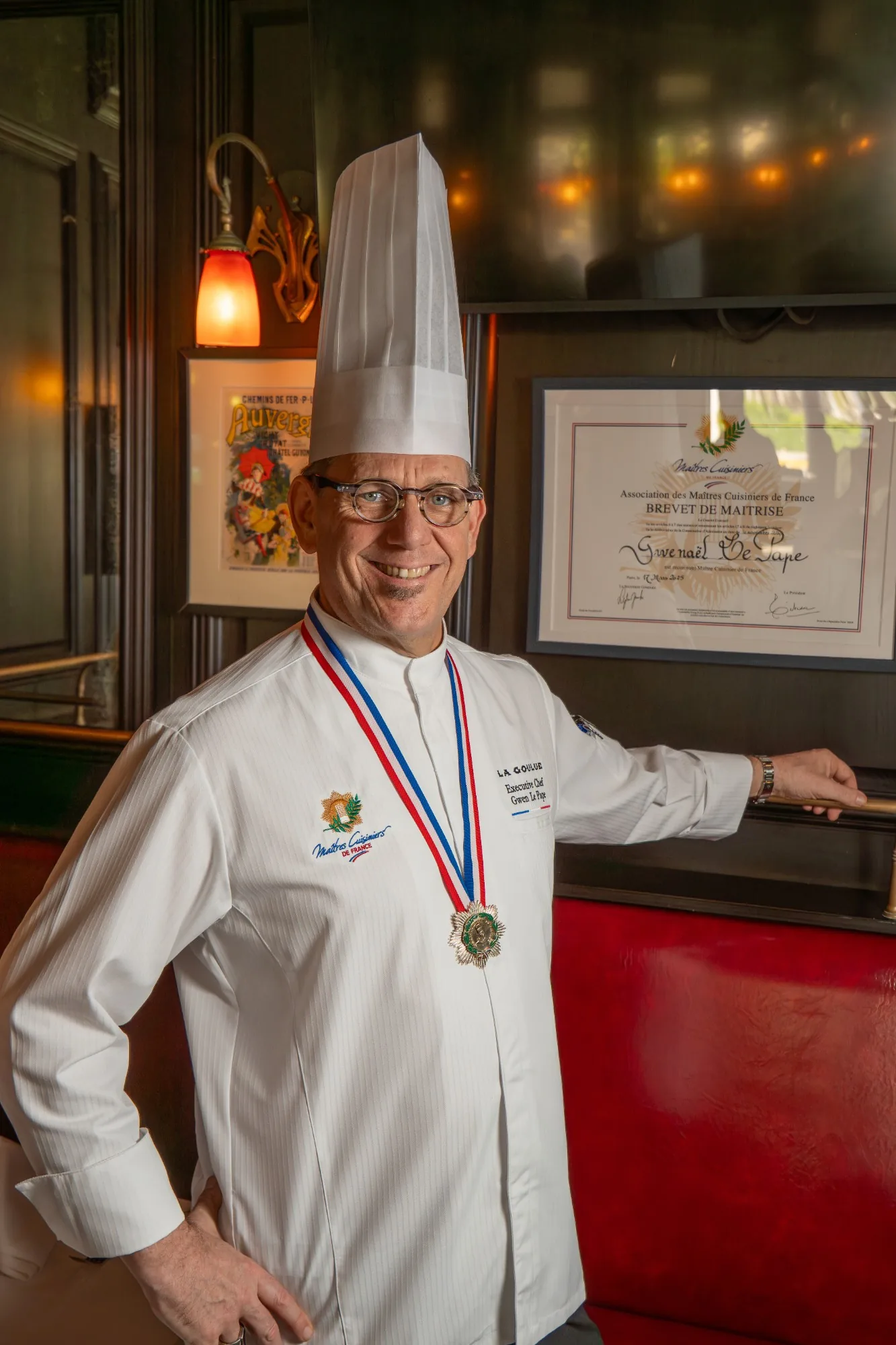 Executive Chef Gwen Le Pape in his toque, wearing the Ma&icirc;tres Cuisiniers de France medal, beside his Brevet de Ma&icirc;trise diploma