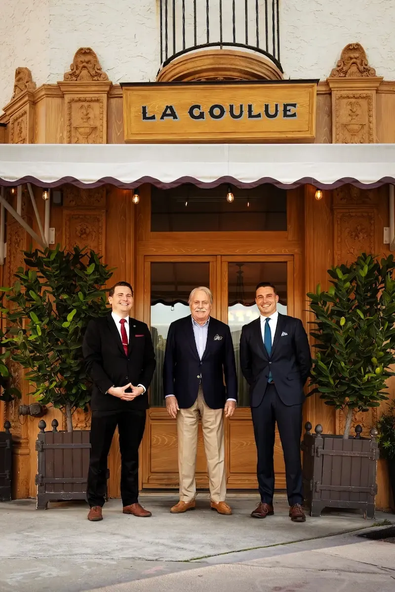 The team at the entrance of La Goulue Palm Beach, under the gilded sign