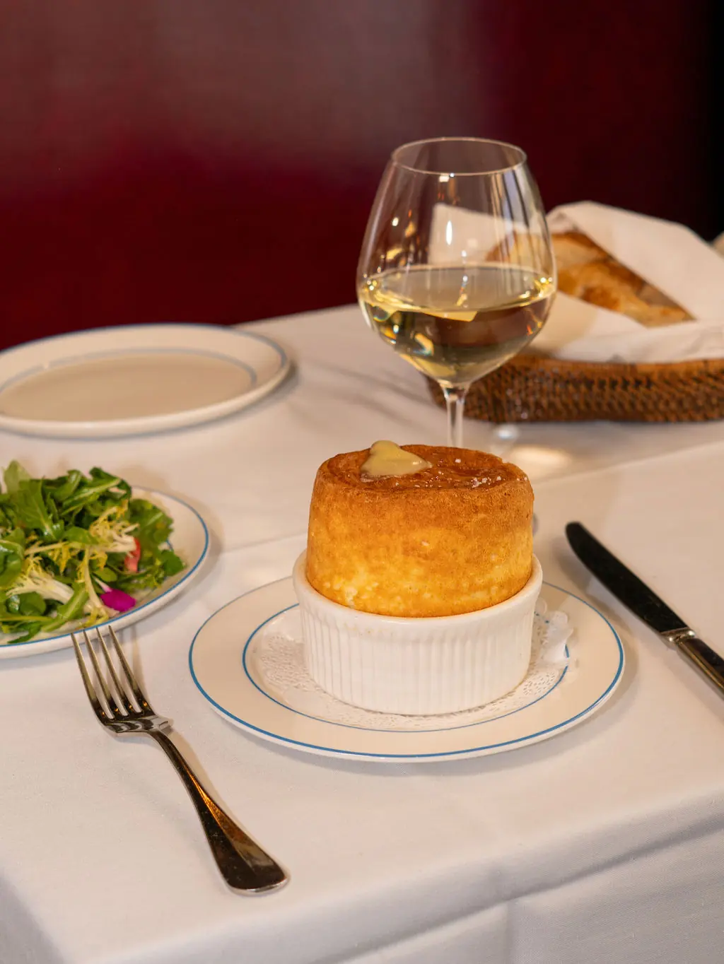 Le Soufflé au Fromage served with a glass of white wine and a green salad
