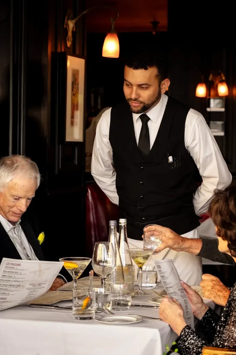 A waiter serving guests in the dining room